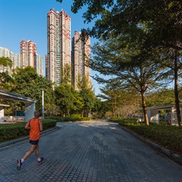 Wide footpaths provide abundant space for joggers jogging through green open spaces.